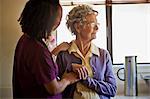 Young nurse comforting a grieving senior woman.