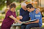 Smiling senior man looking at a photo album with his teenage grandson.