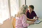 Nurse discussing medication with a senior patient.