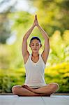 Relaxed young woman meditating on a deck.