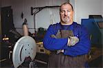 Portrait of welder standing with arm crossed in workshop