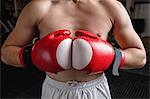 Mid-section of boxer in boxing gloves at fitness studio