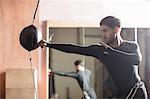 Boxer practicing boxing with punching bag in fitness studio