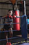 Portrait of female boxer in boxing gloves at fitness studio