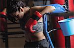 Female boxer taking a break after a practice in fitness studio