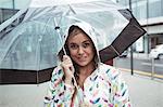 Portrait of beautiful woman holding umbrella during rainy season