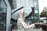 Beautiful woman holding umbrella during rainy season
