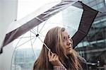 Beautiful woman holding an umbrella during rainy season on street