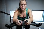 Portrait of pregnant woman working out on exercise bike at gym