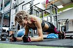 Woman performing push-up exercise in gym