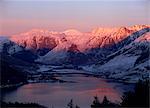 Mountains and Loch Duich head at dusk, with pink light on the snow reflected in water of the lake, from Bealach Ratagain viewpoint, Ratagain Pass, Highlands, Scotland, United Kingdom, Europe