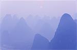 Karst landscape, haze and rising sun, Yangshuo, Guangxi Province, China, Asia