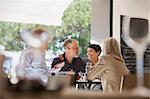 Affectionate couple dining with friends at restaurant table