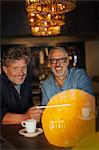 Portrait smiling men using digital tablet and drinking coffee at restaurant table