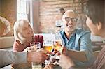 Couples toasting beer and wine glasses at restaurant table