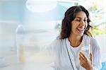 Laughing woman in bathrobe drinking water
