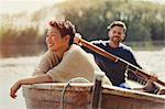 Smiling couple canoeing on sunny lake