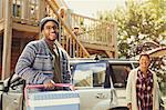 Portrait smiling couple unloading cooler from car outside cabin