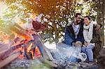 Couple hugging by campfire