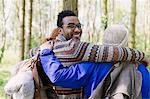 Portrait smiling man hugging friends hiking in woods