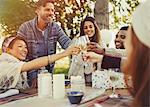 Friends toasting champagne glasses at birthday party patio table