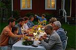 Family enjoying candlelight garden dinner party