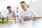 Chef teacher holding bowls in cooking class kitchen