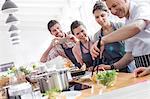 Students watching chef teacher in cooking class kitchen