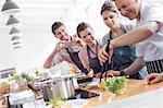 Students watching chef teacher in cooking class kitchen