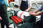 Craftspeople being shown how to use letterpress machine in book arts workshop, mid section