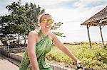 Woman cycling near coast, Gili Trawangan, Lombok, Indonesia