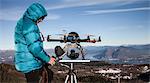Mature man preparing to fly drone, Stresa, Piedmont, Italy