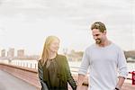 Romantic couple strolling on waterfront at sunset, Battersea Park, London, UK