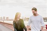 Romantic couple strolling on waterfront at sunset, Battersea Park, London, UK