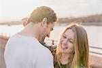 Romantic couple on waterfront at sunset, Battersea Park, London, UK