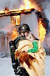 Fireman holding rescued girl, Burning building in background