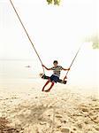 Boy swinging on beach