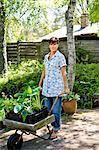 Mature woman with wheel barrow in garden