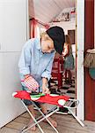 Boy ironing in playhouse