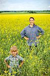 Smiling woman with girl on oilseed rape field