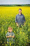 Smiling woman with girl on oilseed rape field