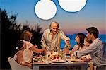 Family enjoying an outdoor dinner on their back deck.