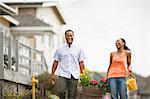 Couple carrying planter of flowers