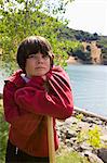 Portrait of a boy leaning on a wooden stick.