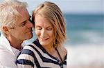 Mid adult woman being affectionate with her husband on the beach.