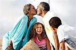 Children laughing at their grandparents kissing.