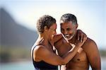 Mid adult couple standing with their arms around each other on a beach.