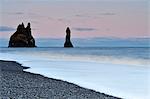 Limestone pillars in sea at dusk