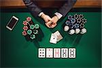 Elegant male poker player's hands with chips stacks, cards and smartphone, top view