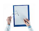 Doctor writing a prescription on a blank sheet and holding glasses on white background, top view
